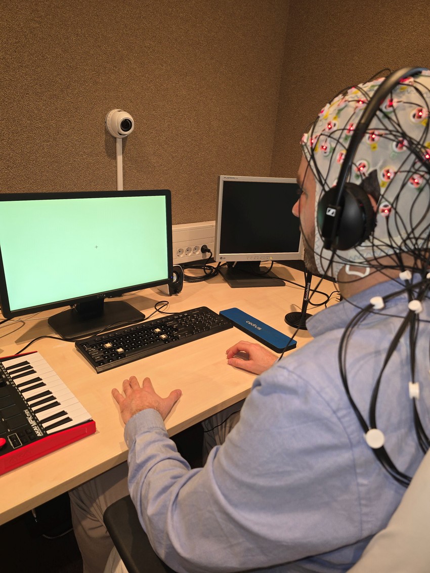 A képen a kutatás egyik résztvevője látható, EEG sapkával a fején